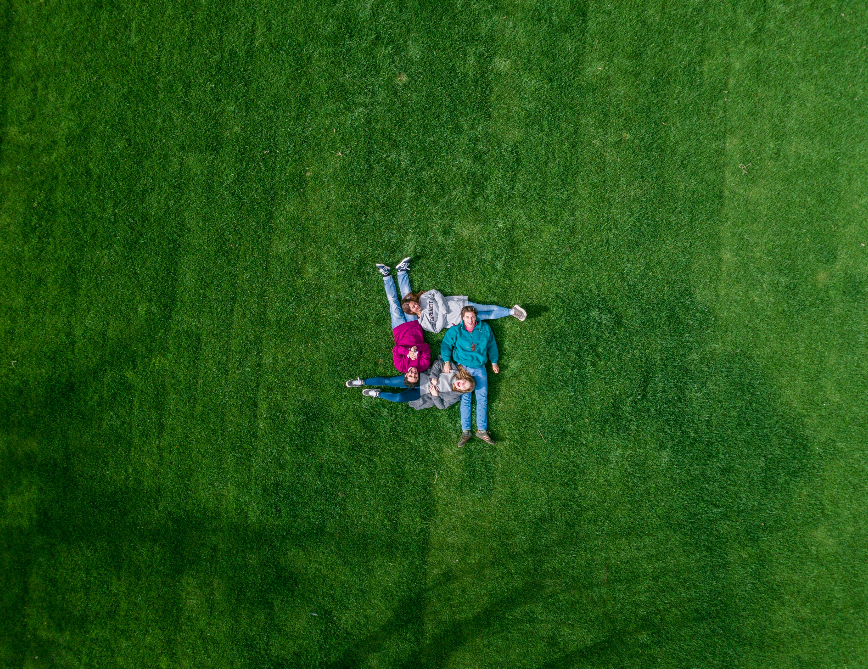 friends forming a hashtag sign on the grass