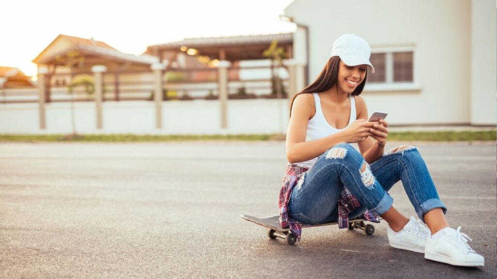 girl answering Instagram DMs on a skateboard