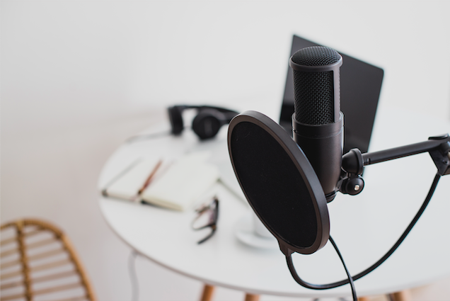 podcast microphone in front of small workspace area