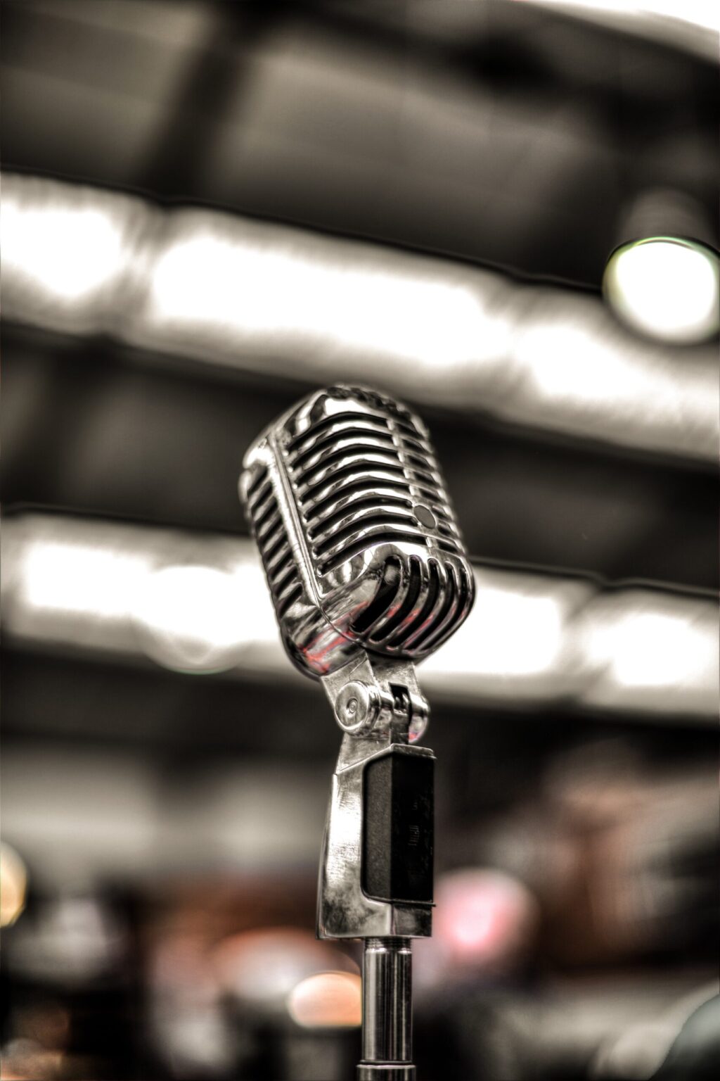 An old-fashioned microphone is shown in the foreground with a blurred background