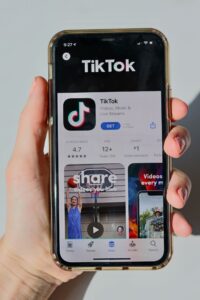 A person holds an iPhone with the TikTok app pulled up in the App Store. 