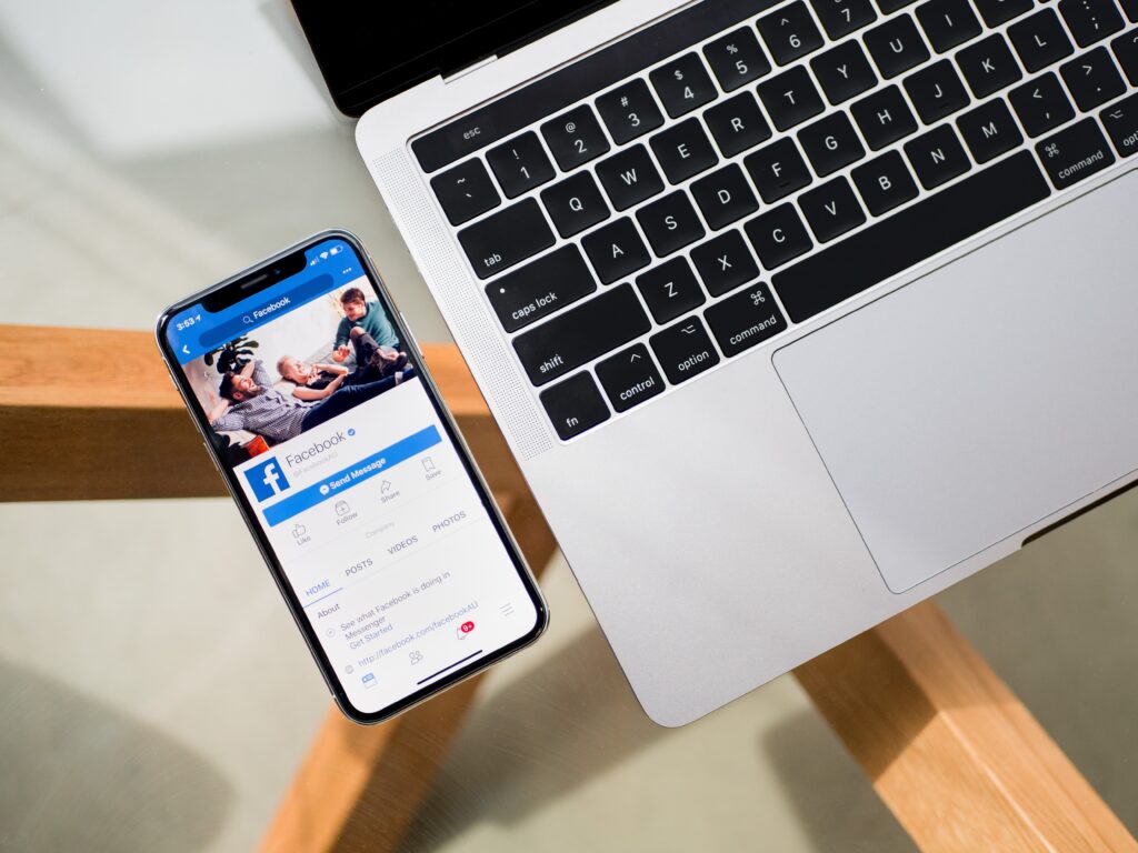 facebook messenger on a phone next to a laptop