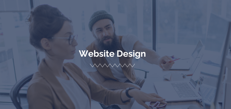 A web designer and copywriter work together on their laptops and monitors to incorporate all aspects of Brand Journalism into a website’s design and copy.
